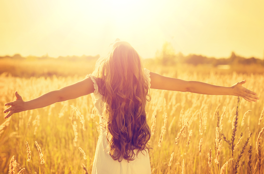 Autumn Girl enjoying nature on the field. Beauty Girl Outdoors raising hands in sunlight rays. Beautiful Teenage Model girl in white dress running on the Field, Sun Light. Glow Sun. Free Happy Woman
